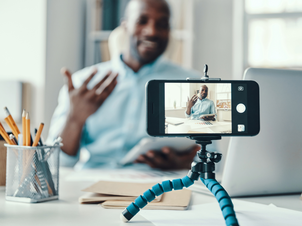 Young man recording himself while presenting financial documents
